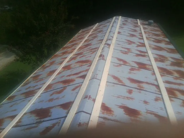 Rusted metal roof panels with new wood purlins before replacement — Storm Damage Roof Repair in Lyndonville by Roofing Brothers